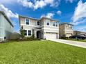 Inviting two-story home with lush green lawn, landscaping and a two-car garage at 8923 Sw 50Th Ave, Ocala, FL 34476