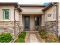 Charming front entrance featuring stone pillars, decorative accents, and a welcoming glass-paned door at 9761 Sw 74Th Pl, Ocala, FL 34481