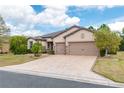 Beautiful home featuring a paver driveway, neutral color scheme, and a well-maintained front yard at 9761 Sw 74Th Pl, Ocala, FL 34481