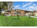 Attractive single-story home with a lush lawn, mature trees, and a covered carport at 520 S Orange Ave, Fort Meade, FL 33841