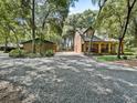 View of the home showcasing a covered porch, adjacent fenced yard and a spacious driveway at 4845 Sw 78Th Ave, Bushnell, FL 33513