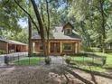 Inviting single-Gathering home with stone pillar accents, fenced front yard, and mature trees at 4845 Sw 78Th Ave, Bushnell, FL 33513