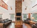 Stunning living room with high ceilings, stone fireplace, wood floors, and large windows at 4845 Sw 78Th Ave, Bushnell, FL 33513