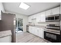 Modern kitchen featuring stainless steel appliances, white cabinetry, and granite countertops at 1126 Waterview E Blvd, Lakeland, FL 33801