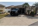 Home showcasing a spacious driveway, lush landscaping, and garage, exuding a welcoming ambiance at 3105 Carrollton Ct, The Villages, FL 32162