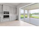Modern kitchen with stainless steel appliances, sleek gray cabinets, and a scenic outdoor view at 5646 Nevis Ter, Kissimmee, FL 34758