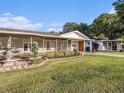 A charming single-story home featuring a screened-in porch and a well-manicured lawn at 915 E Lake Parker Dr, Lakeland, FL 33801