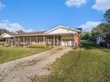 Attractive single-story home with a gravel driveway, screened-in porch and attached garage at 915 E Lake Parker Dr, Lakeland, FL 33801