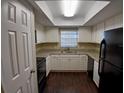 Bright kitchen with granite countertops, white cabinets and modern black appliances at 1135 Linkside Ct, Apopka, FL 32712