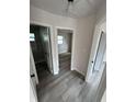 Bright hallway featuring gray wood-look flooring, white doors, leading to the bathroom, closet, and bedroom at 1460 Marvin C Zanders Ave, Apopka, FL 32703