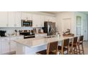 Modern kitchen featuring white cabinets, stainless steel appliances, an island with seating, and ample counter space at 1908 Rosewood Cir, Lakeland, FL 33810