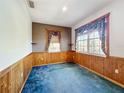 Cozy bedroom featuring wood paneled wainscoting and two windows offering lots of natural light at 2920 Ewell Rd, Lakeland, FL 33811