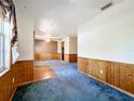 Spacious living area with wood paneled wainscoting, blue carpeting and great open floor plan at 2920 Ewell Rd, Lakeland, FL 33811