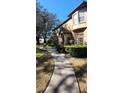 Charming exterior view of the townhome featuring lush landscaping, a private walkway, and inviting curb appeal at 6372 Raleigh St # 1911, Orlando, FL 32835