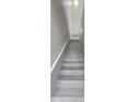Bright stairway featuring neutral gray stairs and white banister, providing an elegant transition between levels at 6372 Raleigh St # 1911, Orlando, FL 32835