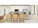 Modern kitchen boasts stainless steel appliances, sleek white cabinets, and a stylish breakfast bar with seating at 7157 Sienna Oak Aly, Orlando, FL 32829