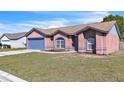 Inviting single-Gathering home showcasing a well-maintained lawn and charming architectural details at 3312 Sangria Pass, Lakeland, FL 33811