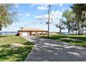 Charming home featuring a metal roof, a garage, and a lengthy driveway surrounded by a lush lawn at 830 County Rd 457, Lake Panasoffkee, FL 33538