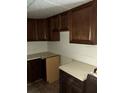 Basic kitchen with dark wood cabinets, simple countertops, and functional layout, ready for renovation at 102 Se 6Th Ave, Mulberry, FL 33860