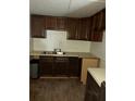 Functional kitchen with dark wood cabinets, double sink, and simple countertops, ready for customization at 102 Se 6Th Ave, Mulberry, FL 33860