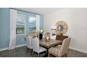 Bright dining room featuring a wooden table with seating for six, complemented by large windows and light blue accent wall at 1906 Clear Sky Dr, Kissimmee, FL 34744