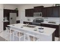 Modern kitchen features stainless steel appliances, dark wood cabinets, a center island and plenty of counter space at 2542 Peace Of Mind Ave, Kissimmee, FL 34744