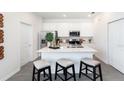 Bright kitchen features white cabinets, an island with barstool seating, and stainless steel appliances at 2256 Red Sun St, Apopka, FL 32703
