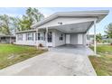 Single-story house showcasing a wide driveway and covered carport area at 122 2Nd Jpv St, Winter Haven, FL 33880