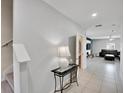 View of tiled foyer, staircase and living room with a modern decorative table at 1773 Yellow Trl, Lakeland, FL 33801