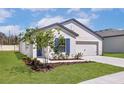 Well-maintained home featuring a manicured lawn, blue shutters, and a two-car garage at 1786 White Elephant Loop, Winter Haven, FL 33884