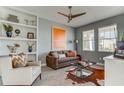 Comfortable living room featuring a ceiling fan, neutral walls, shelving, and two large windows at 4117 Jespersen St, Apopka, FL 32712