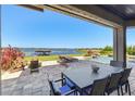 Outdoor patio featuring a dining area, lounge chairs, and a pool overlooking a serene lake at 7769 Summerlake Pointe Blvd, Winter Garden, FL 34787