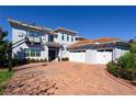 Beautiful home featuring a balcony, a three car garage and a basketball hoop over a brick driveway at 108 Stanton Estates Cir, Winter Garden, FL 34787