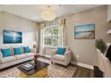 Comfortable living room with sofa, accent chair, and a large window that provides natural light at 130 Southern Pecan Cir # 205, Winter Garden, FL 34787