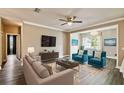 Bright living room with modern furnishings, including sofa, chairs, and hardwood-style flooring at 130 Southern Pecan Cir # 205, Winter Garden, FL 34787