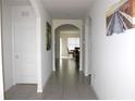 Bright hallway showcasing arched doorways and tile flooring, leading to other areas of the house at 1823 Pristine Loop, Lakeland, FL 33811