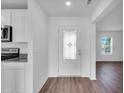 Bright foyer with wood-look floors, decorative front door and view into the living room at 2674 Sw 165Th Street Rd, Ocala, FL 34473
