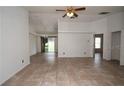 Open-concept living room with tile flooring, ceiling fan, and access to the backyard at 250 Ashley Rd, Mascotte, FL 34753