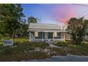 Charming single Gathering home at twilight featuring a welcoming front porch at 215 Maple Ln, Fort Meade, FL 33841