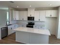 Modern kitchen with sleek white cabinets, quartz countertops, and stainless steel appliances at 15088 Grove Lake Dr, Winter Garden, FL 34787