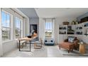 Cozy home office with a work desk, chair, bookshelves, accent chair and large windows at 15113 Grove Lake Dr, Winter Garden, FL 34787