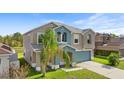 Two-story home with a palm tree, a two-car garage and views of a pond at 3189 Kearns Rd, Mulberry, FL 33860