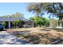 Exterior elevation of the home featuring mature landscaping and a well-maintained lawn at 1000 Andrea Ridge Ct, Kissimmee, FL 34747