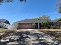 Home exterior featuring a grey roof, stone chimney, and beautiful curb appeal at 1000 Andrea Ridge Ct, Kissimmee, FL 34747