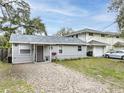 Well-maintained one-story home with a gray exterior, gravel yard, and manicured lawn at 5125 Isabelle Ave, Port Orange, FL 32127