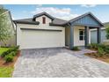 Inviting home exterior features a paver driveway, attached garage, and well-maintained landscaping at 6057 Sacred Oak Ave, Mount Dora, FL 32757