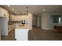 Bright kitchen with white cabinetry, a central island, and stainless steel appliances at 6057 Sacred Oak Ave, Mount Dora, FL 32757