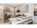 Modern kitchen featuring stainless steel appliances, light gray cabinets, and a breakfast bar at 7347 Capstone Dr, Groveland, FL 34736