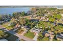 An aerial view displays a well-maintained home with lush greenery and a nearby lake at 1841 5Th Se St, Winter Haven, FL 33880