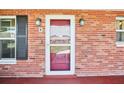 Front door with a brick exterior, two sconces and a storm door at 1841 5Th Se St, Winter Haven, FL 33880